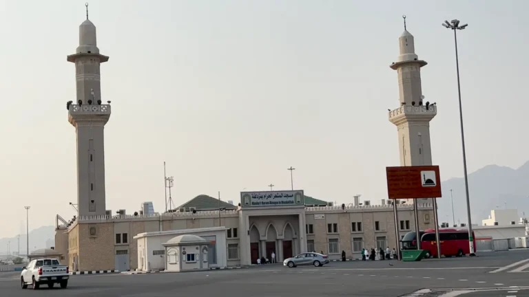 Masjid al-Mashar al-Haram during Hajj in Muzdalifah under night sky with pilgrims praying