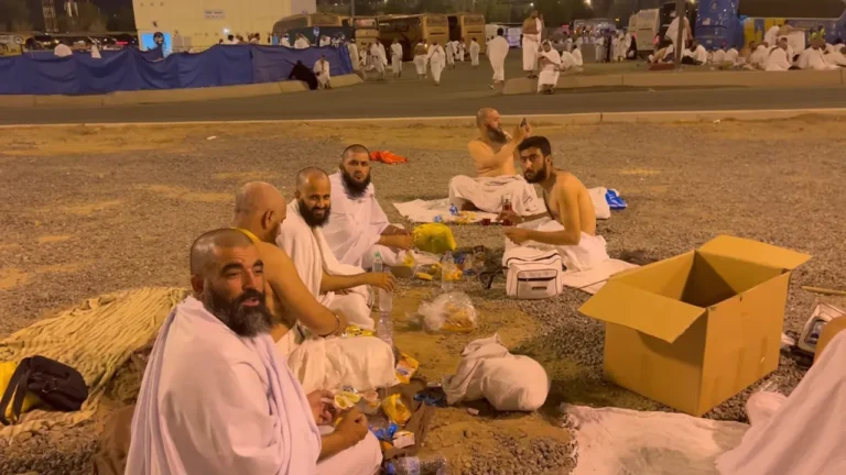 Muzdalifah in Hajj – pilgrim holding pebbles at Mash’ar Al-Haram under night sky