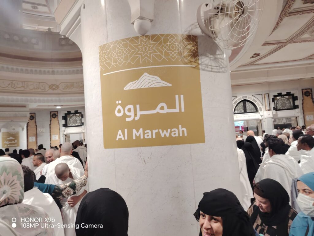 Directional arrows on the Masjid al-Haram walkway showing start point, end point, green-marker running section for men, and lap flow for completing seven rounds